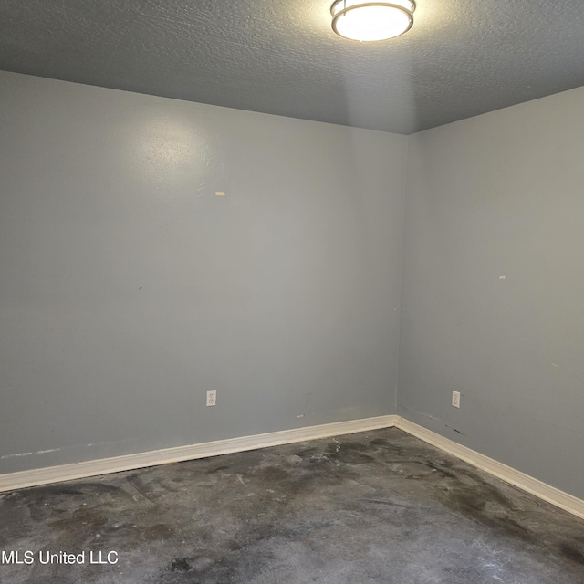 empty room with concrete floors and a textured ceiling