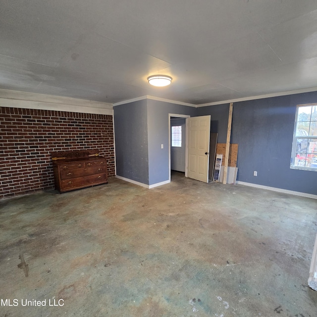 interior space with crown molding, brick wall, and concrete flooring