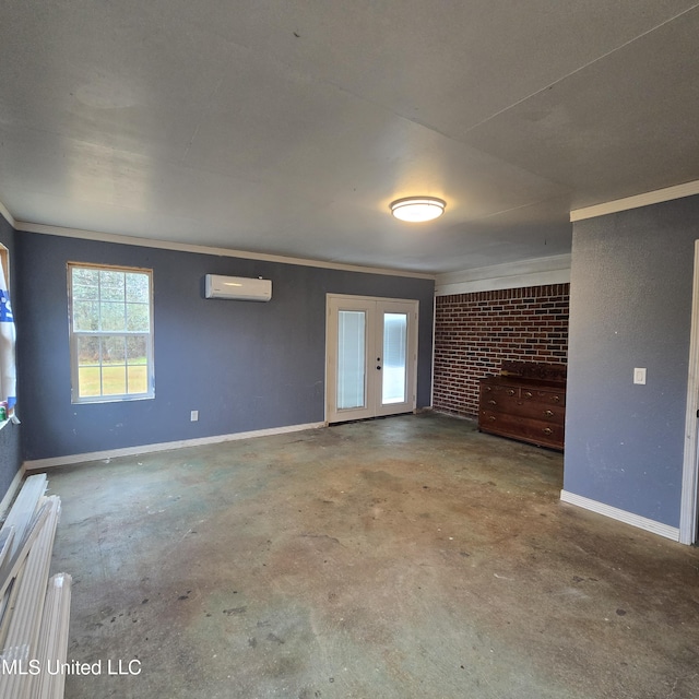 spare room featuring brick wall, a wall mounted air conditioner, ornamental molding, french doors, and concrete floors
