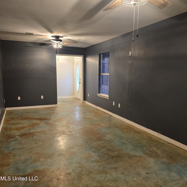 unfurnished room with ceiling fan and concrete floors