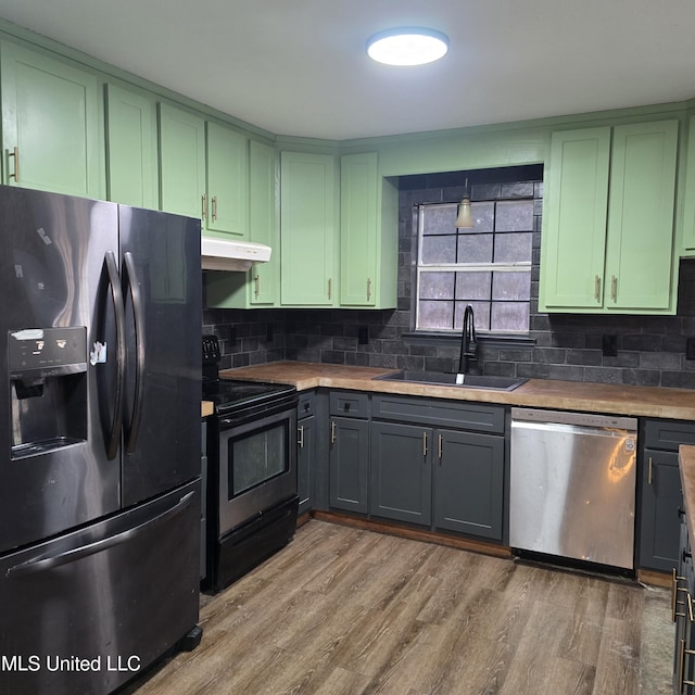 kitchen featuring sink, light hardwood / wood-style flooring, wooden counters, green cabinets, and appliances with stainless steel finishes