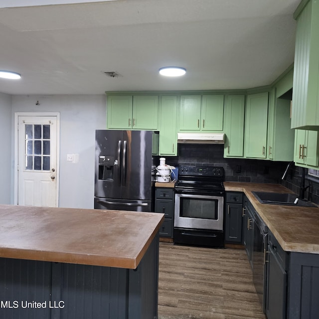kitchen with stainless steel appliances, sink, and green cabinetry