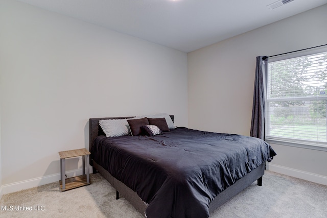 bedroom featuring multiple windows and light colored carpet