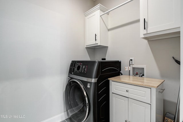 laundry area featuring washer / dryer and cabinets