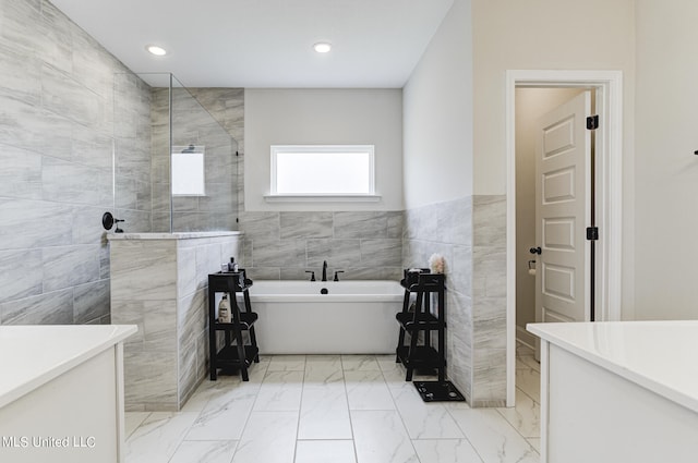 bathroom featuring tile walls and separate shower and tub