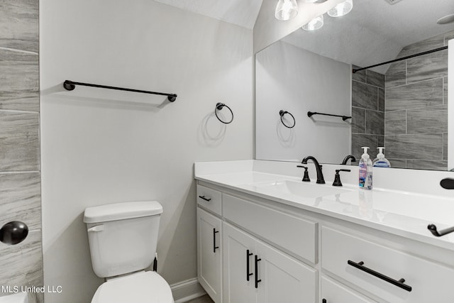 bathroom featuring vanity, tiled shower, a textured ceiling, and toilet