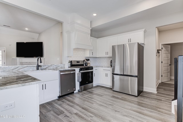 kitchen featuring appliances with stainless steel finishes, light hardwood / wood-style flooring, and white cabinets