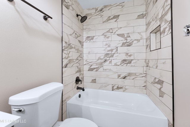 bathroom with tiled shower / bath combo and toilet