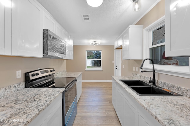 kitchen featuring sink, appliances with stainless steel finishes, white cabinets, and light hardwood / wood-style floors