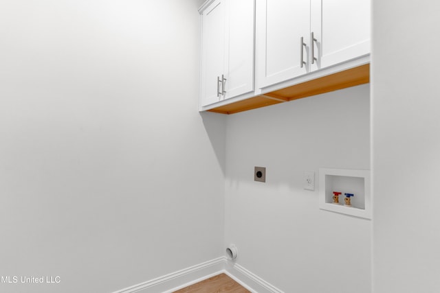 washroom featuring hookup for an electric dryer, washer hookup, baseboards, cabinet space, and wood finished floors