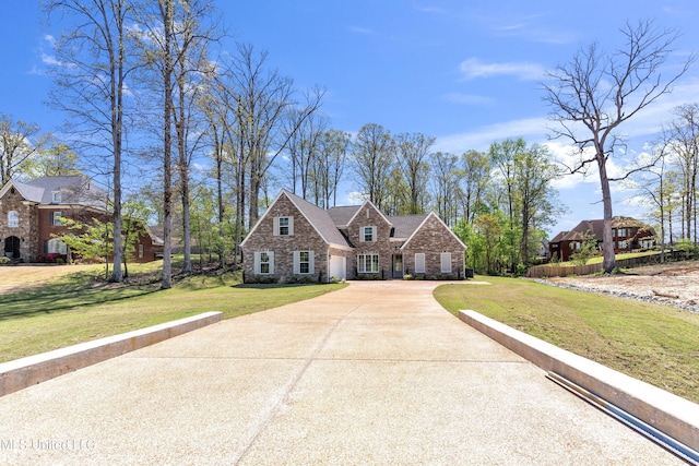 view of front of property with a front lawn, driveway, and stone siding