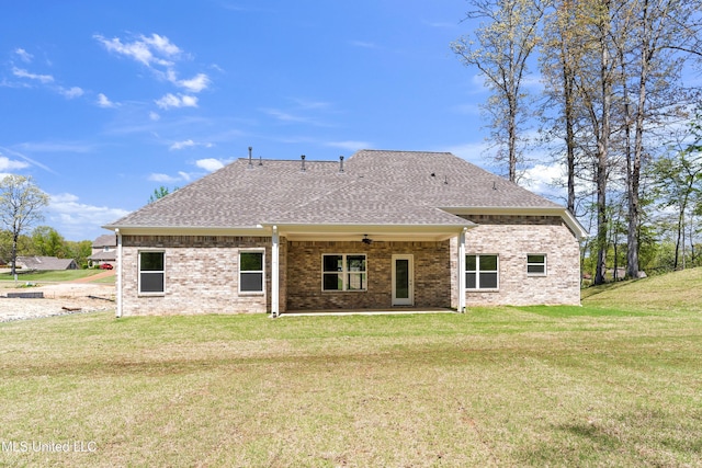 rear view of house featuring a shingled roof, a patio area, a yard, a ceiling fan, and brick siding