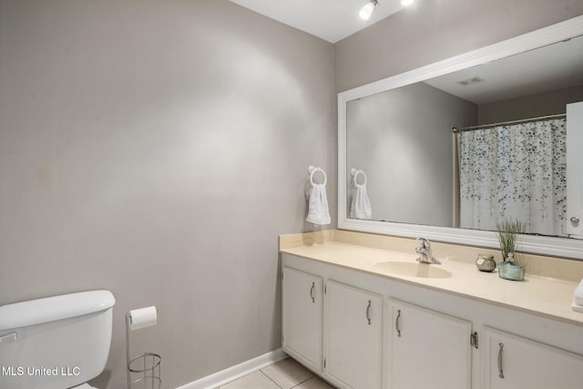 bathroom with tile patterned floors, walk in shower, vanity, and toilet