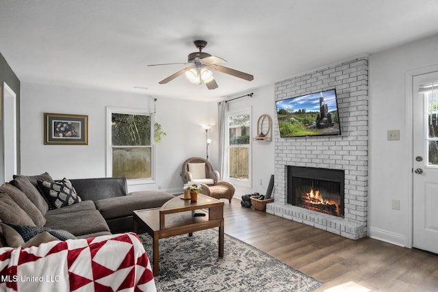 living room with hardwood / wood-style flooring, a brick fireplace, plenty of natural light, and ceiling fan