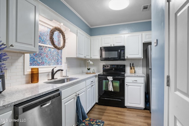 kitchen with black appliances, crown molding, white cabinetry, and sink