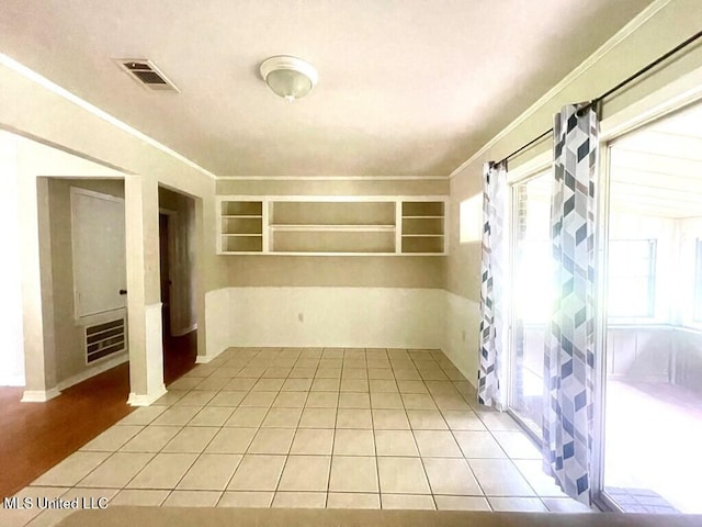 tiled spare room with ornamental molding