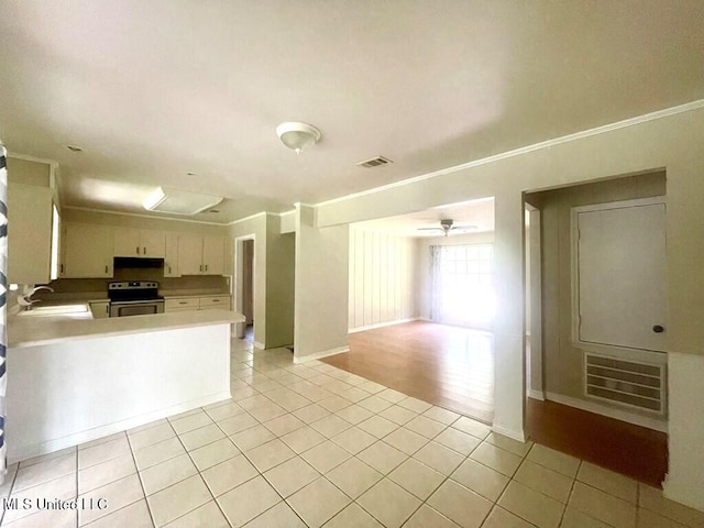 kitchen featuring kitchen peninsula, ceiling fan, stainless steel electric stove, sink, and light tile patterned flooring