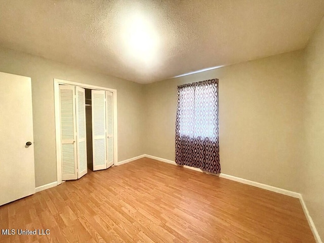 unfurnished bedroom featuring light wood-type flooring and a textured ceiling