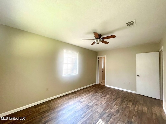 empty room with dark hardwood / wood-style floors and ceiling fan