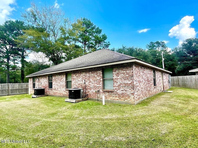 view of side of property with a yard and central AC unit