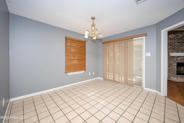 8113 Barron Rd, Moss Point, MS 39562 - unfurnished room with a chandelier, baseboards, light tile patterned floors, a brick fireplace, and a textured ceiling
