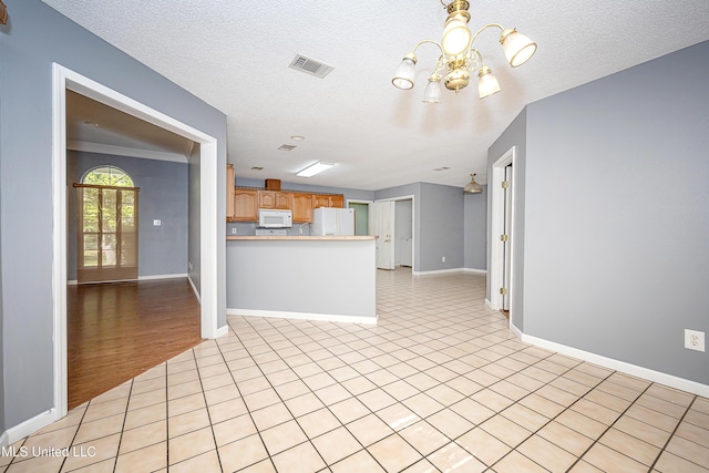 8113 Barron Rd, Moss Point, MS 39562 - kitchen featuring white appliances, a chandelier, a peninsula, baseboards, and light tile patterned floors