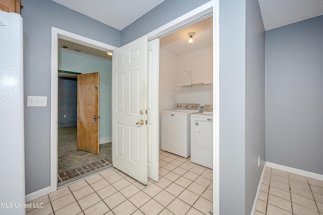 8113 Barron Rd, Moss Point, MS 39562 - washroom with washing machine and dryer, light tile patterned floors, baseboards, and a textured ceiling