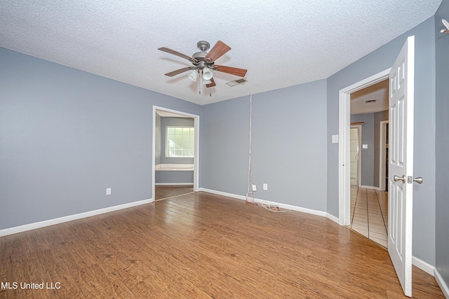 8113 Barron Rd, Moss Point, MS 39562 - empty room featuring a ceiling fan, a textured ceiling, wood finished floors, and baseboards