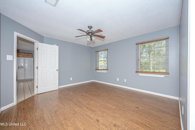 8113 Barron Rd, Moss Point, MS 39562 - empty room with a textured ceiling, healthy amount of natural light, ceiling fan, wood finished floors, and baseboards