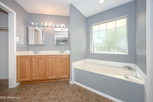 8113 Barron Rd, Moss Point, MS 39562 - bathroom featuring a garden tub, double vanity, and baseboards