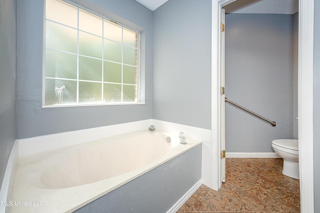 8113 Barron Rd, Moss Point, MS 39562 - bathroom featuring a bath, toilet, and stone finish floors