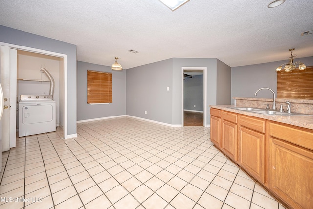 8113 Barron Rd, Moss Point, MS 39562 - kitchen featuring washer / clothes dryer, a sink, a textured ceiling, light countertops, and light tile patterned flooring