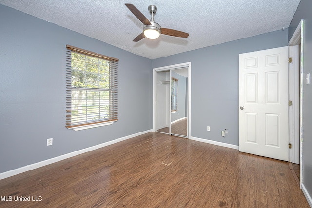 8113 Barron Rd, Moss Point, MS 39562 - unfurnished bedroom featuring a textured ceiling, dark wood-type flooring, a closet, baseboards, and a ceiling fan