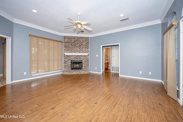 8113 Barron Rd, Moss Point, MS 39562 - unfurnished living room with a textured ceiling, ceiling fan, wood finished floors, a brick fireplace, and baseboards