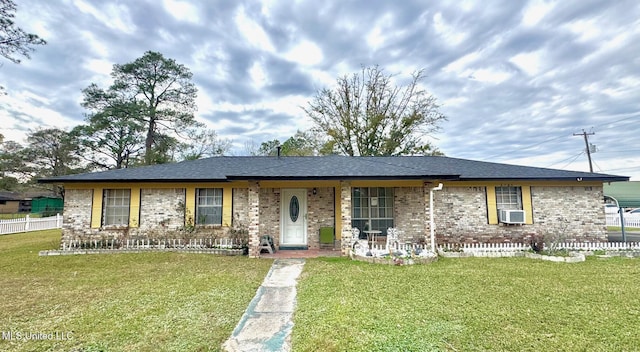 ranch-style home with cooling unit, brick siding, and a front lawn