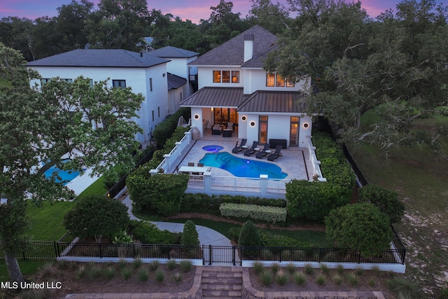 pool at dusk with a patio