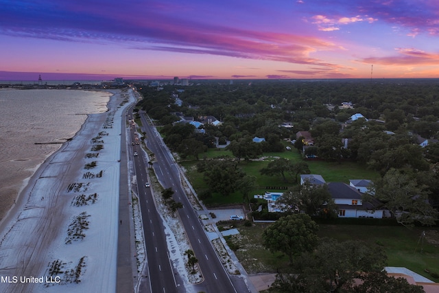 aerial view at dusk featuring a water view