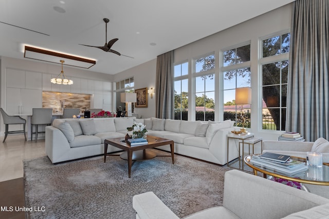 living room featuring ceiling fan with notable chandelier