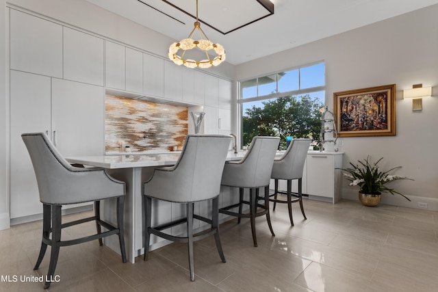 tiled dining room featuring a chandelier