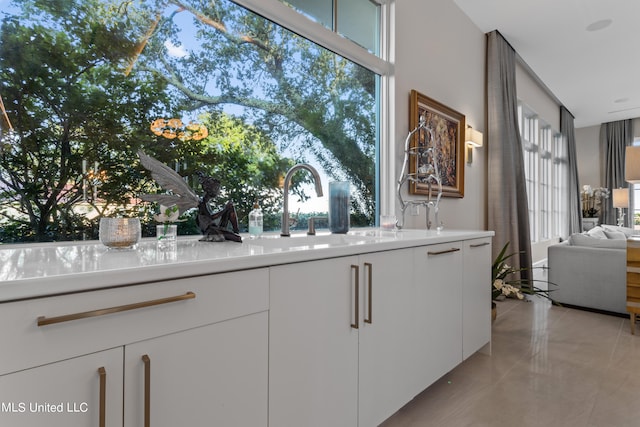 kitchen featuring sink, white cabinetry, and light tile patterned floors