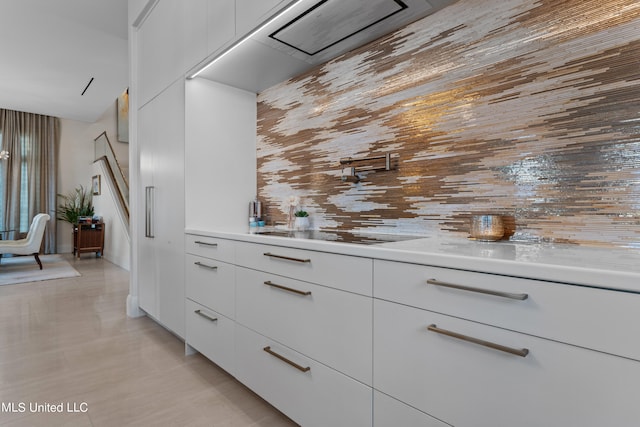 bar featuring white cabinets and black electric cooktop