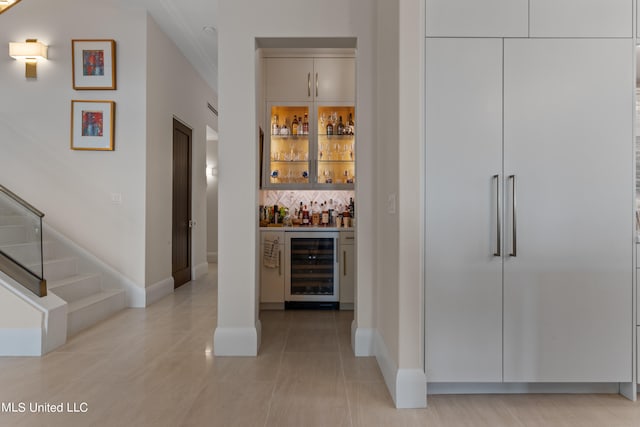 bar featuring light tile patterned flooring, stainless steel built in refrigerator, and beverage cooler