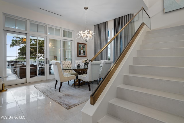 dining space featuring french doors, tile patterned floors, and a chandelier