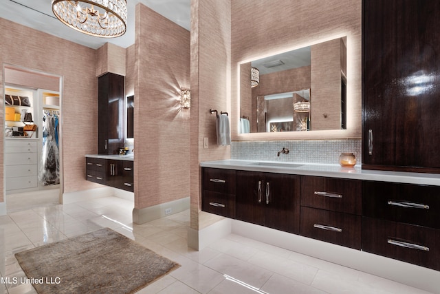 bathroom with vanity, backsplash, a notable chandelier, and tile patterned flooring