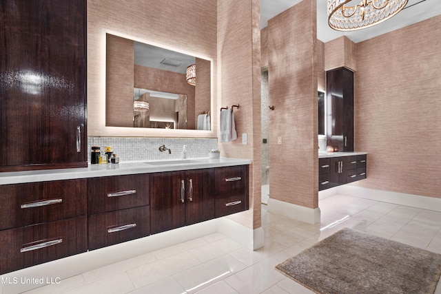 bathroom featuring vanity, a notable chandelier, tasteful backsplash, and tile patterned flooring