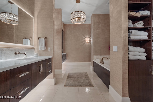 bathroom featuring vanity, tile patterned floors, an inviting chandelier, and a washtub