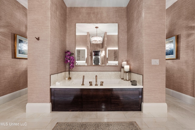 bathroom with tile patterned flooring, an inviting chandelier, and a bathing tub