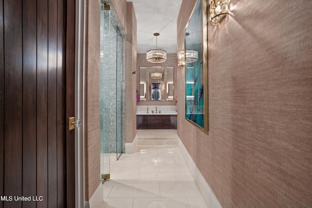 hallway with light tile patterned floors and a chandelier