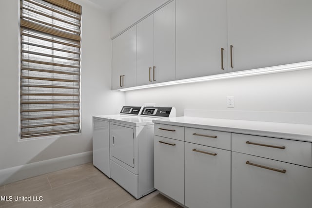 laundry area featuring washer and dryer and cabinets