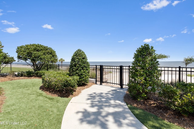 view of gate with a yard and a water view